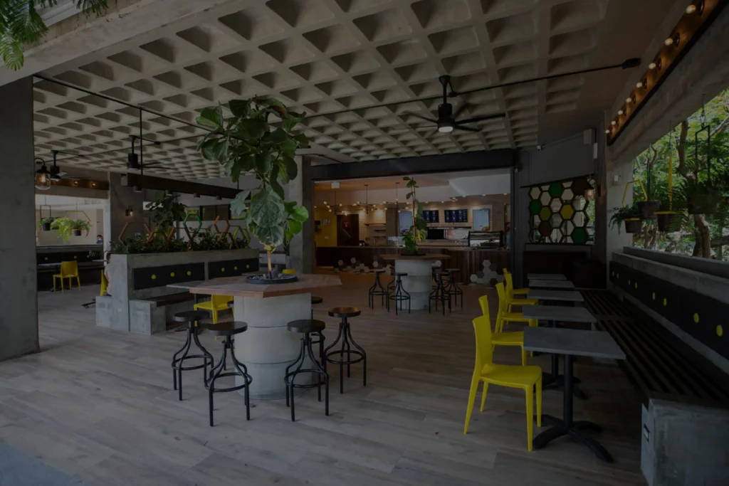 Vista interior de la tienda Café Don Juan en Centro Médico con filtro oscuro semitransparente, mostrando mesas y decoración moderna.