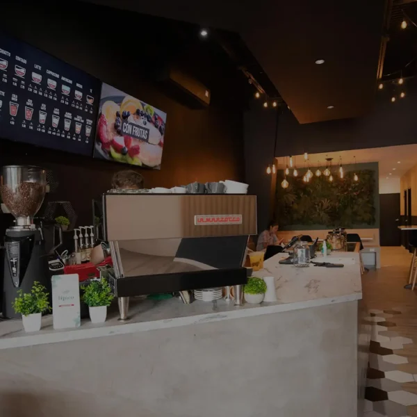 Vista interior de la tienda Café Don Juan en Caguas con filtro oscuro semitransparente, mostrando mesas y decoración moderna.