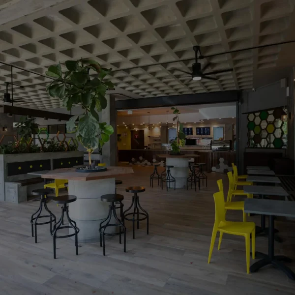 Vista interior de la tienda Café Don Juan en Centro Médico con filtro oscuro semitransparente, mostrando mesas y decoración moderna.